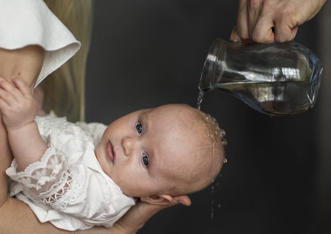 Water being poured over an infant's head at Baptism
